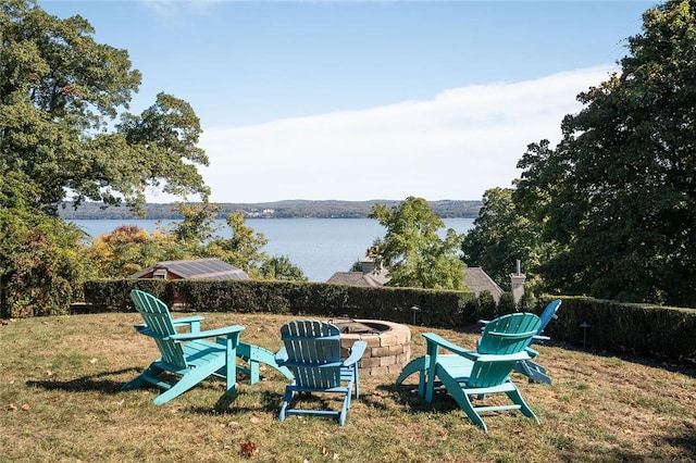 exterior space with a water view and an outdoor fire pit