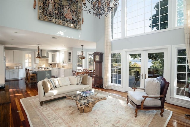 living room featuring dark hardwood / wood-style flooring, a high ceiling, a wealth of natural light, and french doors