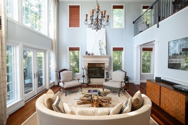 living room with dark hardwood / wood-style flooring, a towering ceiling, and a wealth of natural light