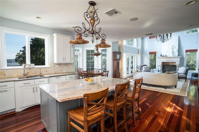 kitchen with dark hardwood / wood-style flooring, a center island, white cabinets, and an inviting chandelier