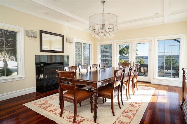 dining room featuring hardwood / wood-style floors, crown molding, a tile fireplace, and an inviting chandelier