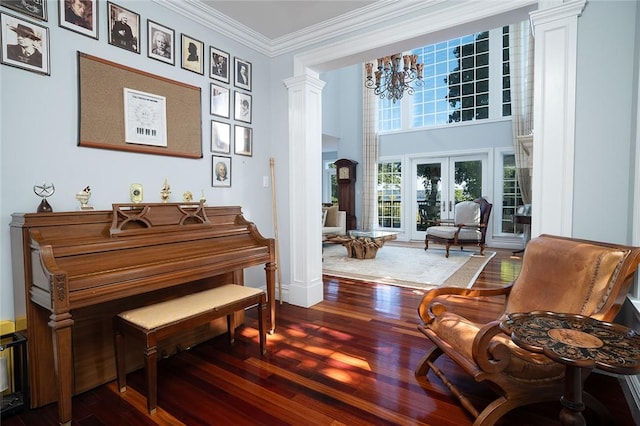 living area featuring a chandelier, crown molding, wood-type flooring, and french doors