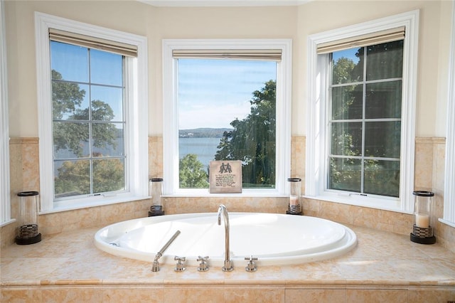 bathroom featuring a water view and tiled tub