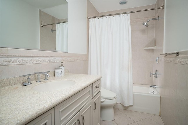 full bathroom featuring tile patterned flooring, toilet, shower / tub combo with curtain, vanity, and tile walls