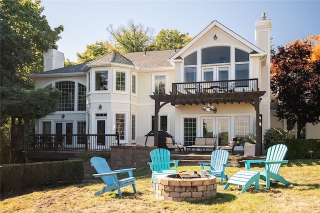 rear view of house with a yard, french doors, and an outdoor fire pit