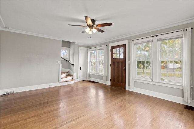 unfurnished living room with hardwood / wood-style floors, ceiling fan, crown molding, and a wealth of natural light