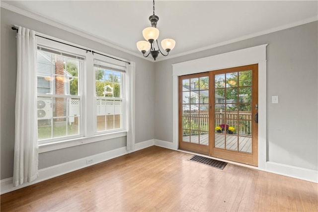 entryway featuring hardwood / wood-style floors, an inviting chandelier, and crown molding