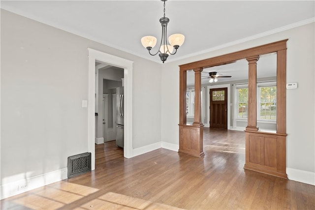 empty room featuring crown molding, a chandelier, and hardwood / wood-style flooring