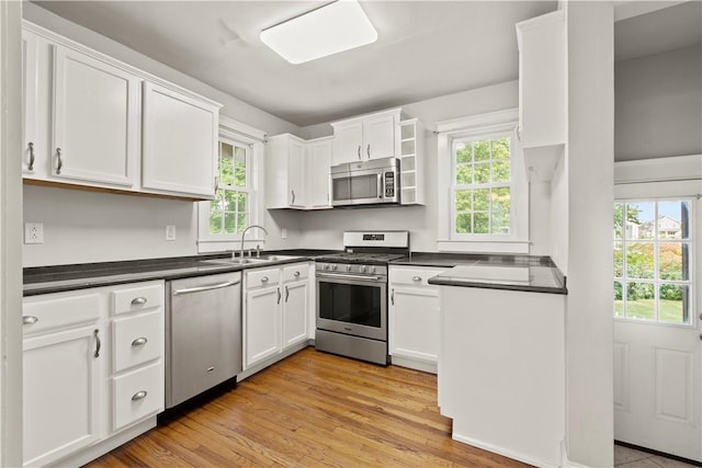 kitchen featuring a wealth of natural light, white cabinets, and appliances with stainless steel finishes