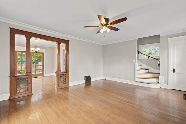 unfurnished living room featuring wood-type flooring, a wealth of natural light, and ornamental molding