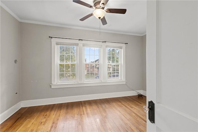 spare room featuring ceiling fan, light wood-type flooring, and crown molding