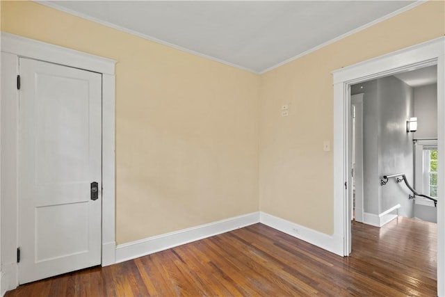 spare room with dark hardwood / wood-style floors and crown molding