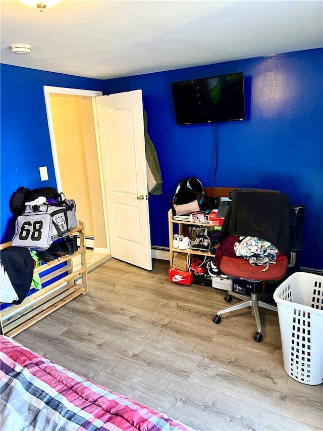 bedroom featuring baseboard heating and light hardwood / wood-style floors