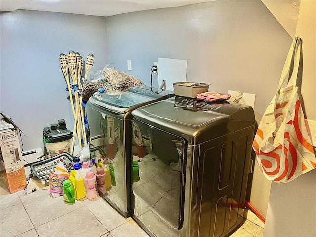 laundry room with washer and clothes dryer and light tile patterned floors