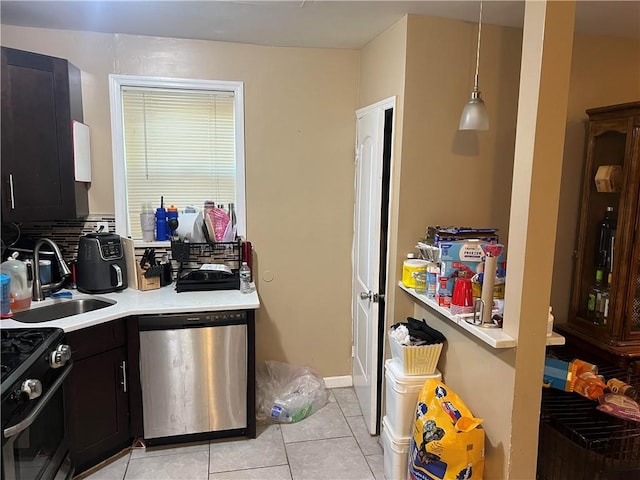 kitchen featuring pendant lighting, sink, light tile patterned floors, and stainless steel appliances