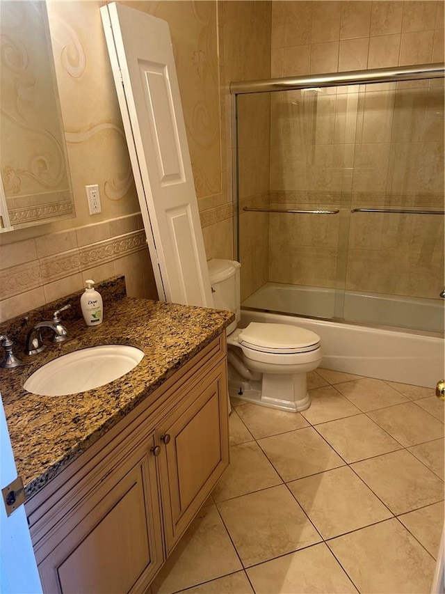 bathroom featuring toilet, a shower with door, and tile walls