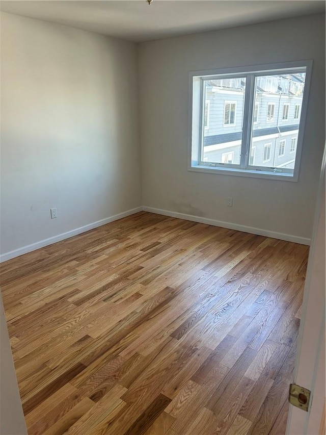 unfurnished room with wood walls and light hardwood / wood-style flooring