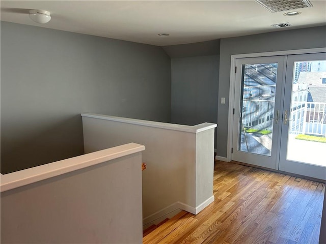 entryway with french doors and light hardwood / wood-style flooring