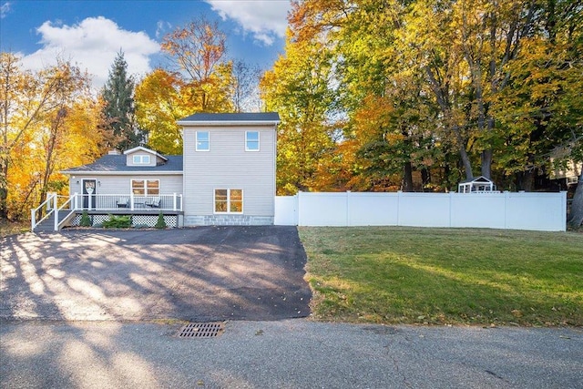 view of front of property with a deck and a front lawn