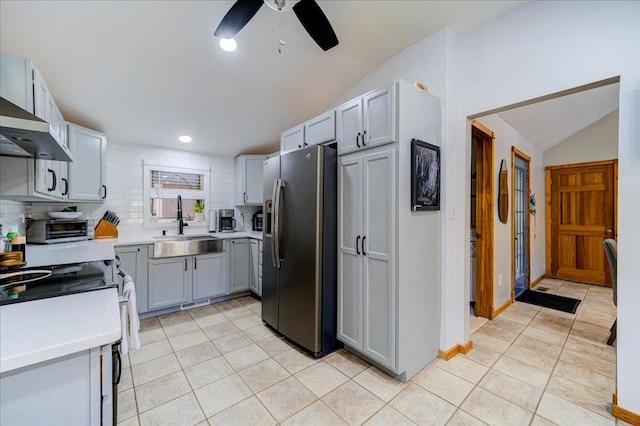 kitchen featuring sink, stainless steel refrigerator with ice dispenser, vaulted ceiling, ceiling fan, and light tile patterned flooring