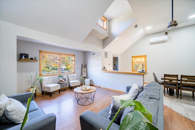 living room with vaulted ceiling, light hardwood / wood-style flooring, and a wall mounted air conditioner