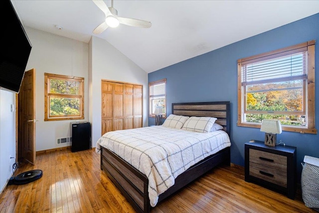 bedroom featuring ceiling fan, a closet, light hardwood / wood-style floors, and lofted ceiling