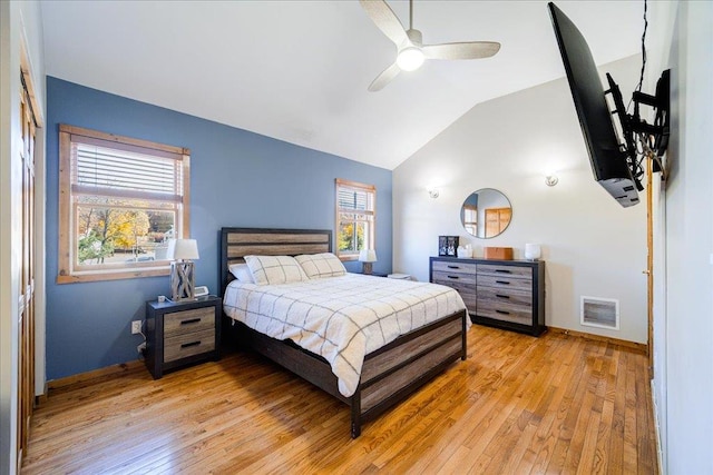 bedroom featuring light hardwood / wood-style floors, vaulted ceiling, and ceiling fan