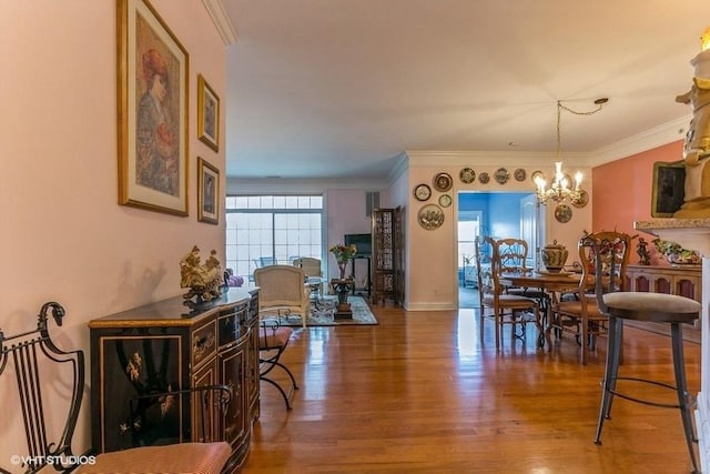 dining space featuring hardwood / wood-style floors, ornamental molding, and a notable chandelier