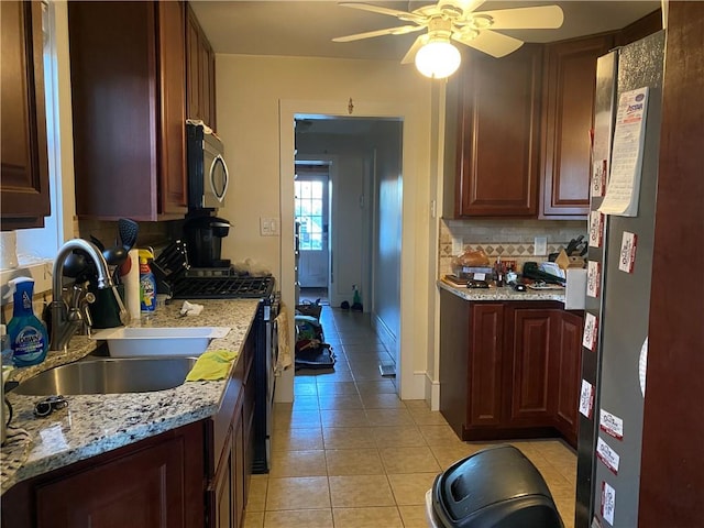 kitchen with tasteful backsplash, stainless steel appliances, ceiling fan, sink, and light tile patterned floors