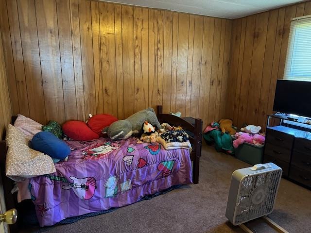 bedroom with wooden walls and carpet floors