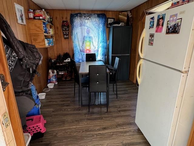 dining room with dark wood-type flooring and wood walls