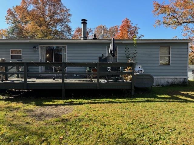 rear view of house with a yard and a deck