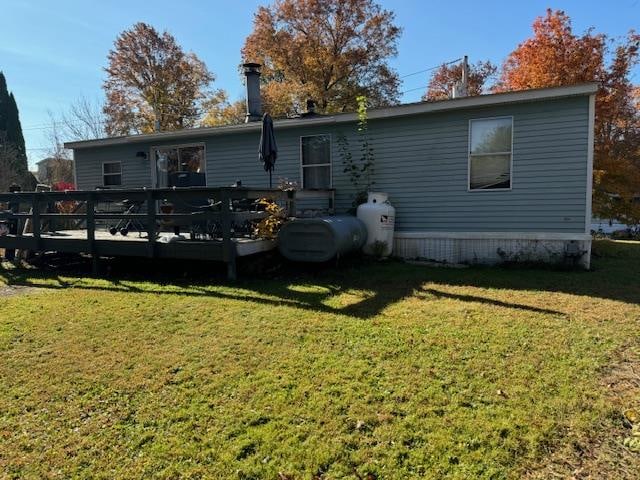 back of property with a yard and a wooden deck