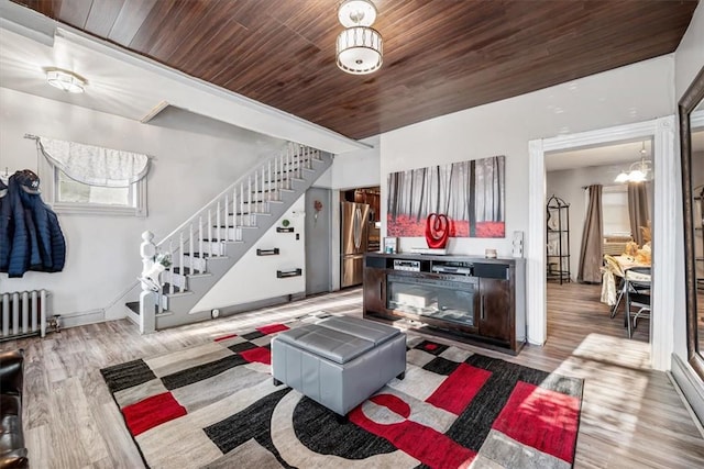 living room with light hardwood / wood-style floors, wood ceiling, radiator, and a chandelier