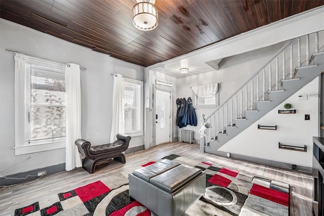 living room with radiator, light hardwood / wood-style flooring, and wood ceiling