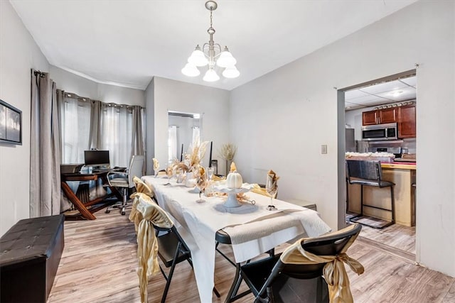 dining room featuring light wood-type flooring and a chandelier