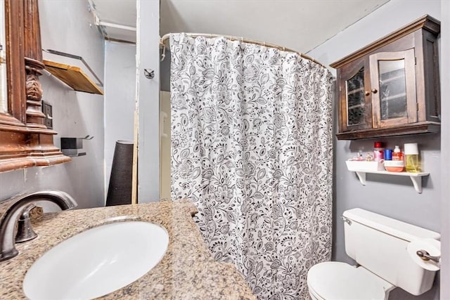 bathroom featuring a shower with curtain, toilet, and sink