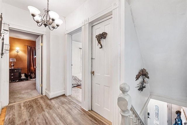 hallway with a notable chandelier and light hardwood / wood-style flooring