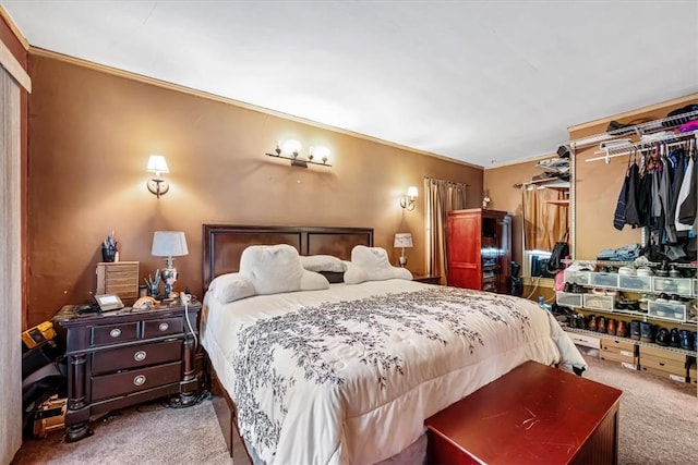 carpeted bedroom with crown molding and a closet