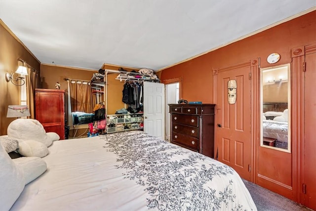 bedroom with carpet floors, crown molding, and a closet