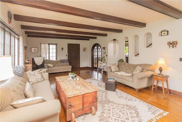 living room featuring beamed ceiling and wood-type flooring