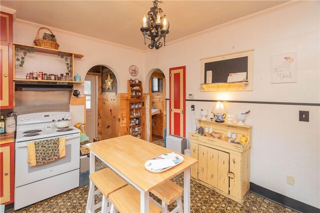 kitchen with an inviting chandelier, white electric stove, pendant lighting, a breakfast bar, and ornamental molding