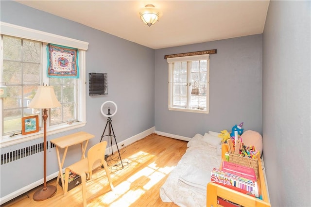 playroom with wood-type flooring and radiator heating unit