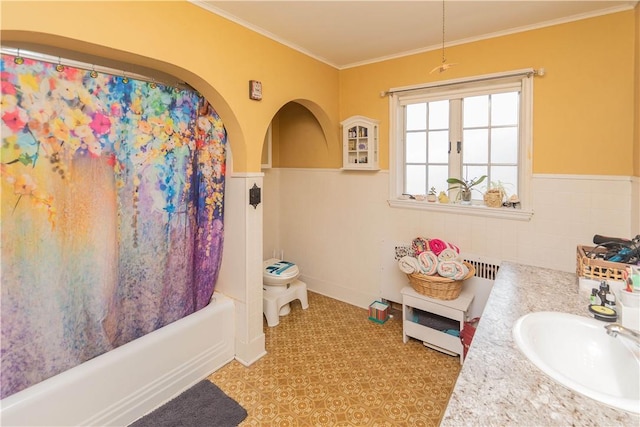 bathroom featuring vanity, crown molding, shower / bathtub combination with curtain, and tile walls