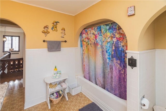 bathroom with hardwood / wood-style flooring, tile walls, and ornamental molding