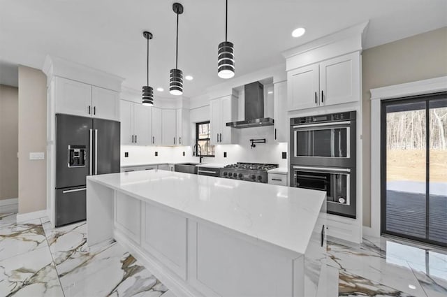 kitchen with a center island, stainless steel appliances, white cabinetry, and wall chimney exhaust hood