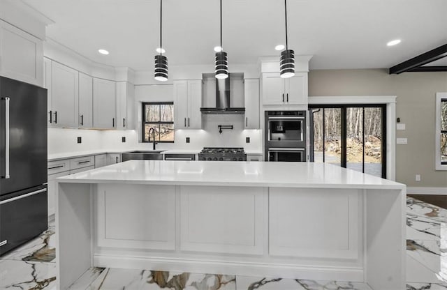 kitchen with wall chimney exhaust hood, sink, stainless steel appliances, and a wealth of natural light