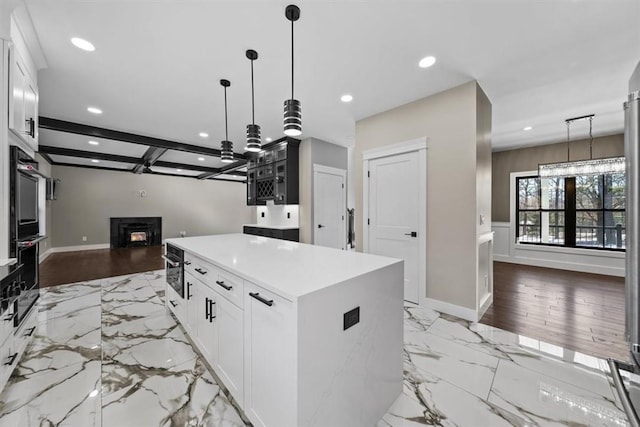 kitchen featuring white cabinets, light hardwood / wood-style flooring, a kitchen island, and hanging light fixtures