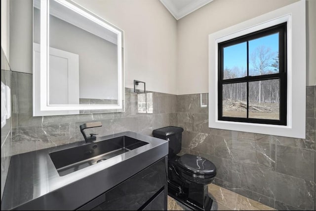 bathroom featuring crown molding, vanity, tile walls, and toilet