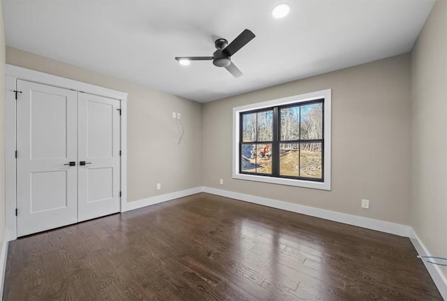 unfurnished bedroom with dark hardwood / wood-style flooring, a closet, and ceiling fan